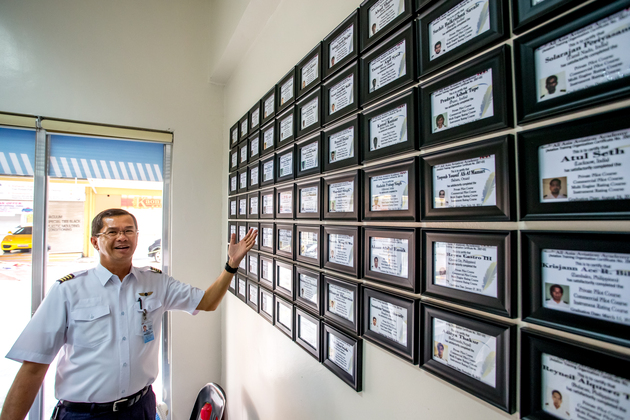AAA Academy achievement wall showcasing pilot graduates and training milestones under the TAKUMI philosophy