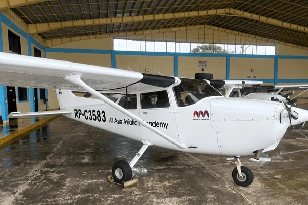 AAA Cessna 172R training aircraft parked inside the academy hangar