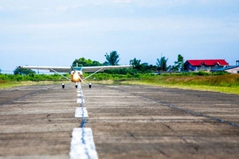 Pesawat latih bermesin tunggal terlihat di landasan pacu sebuah lapangan terbang.