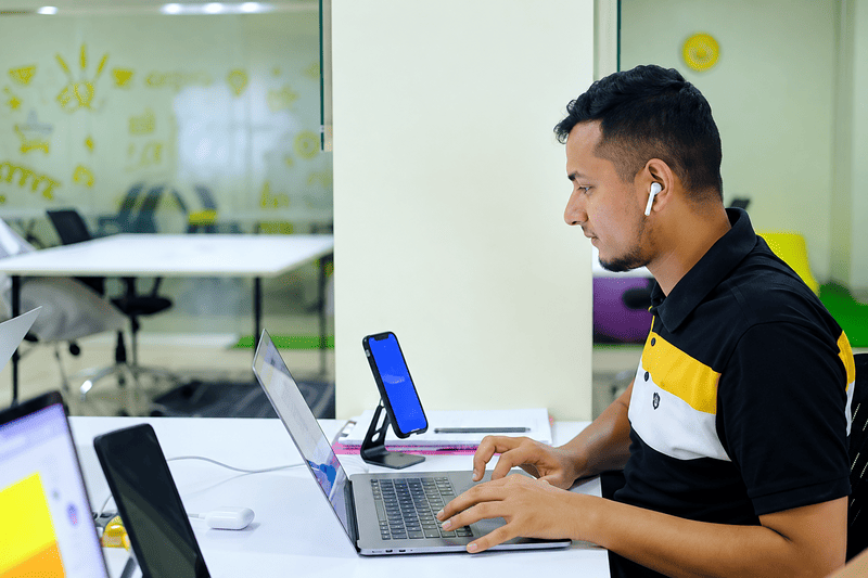 Seseorang menggunakan laptop di meja kerja dalam suasana belajar.